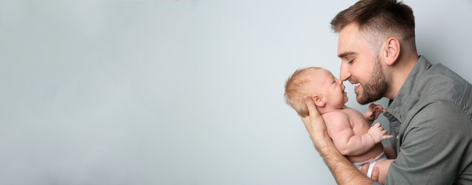 Image of Father with his baby son on light grey background, space for text. Banner design