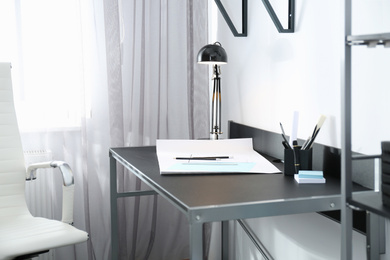 Stylish workplace with modern lamp and stationery