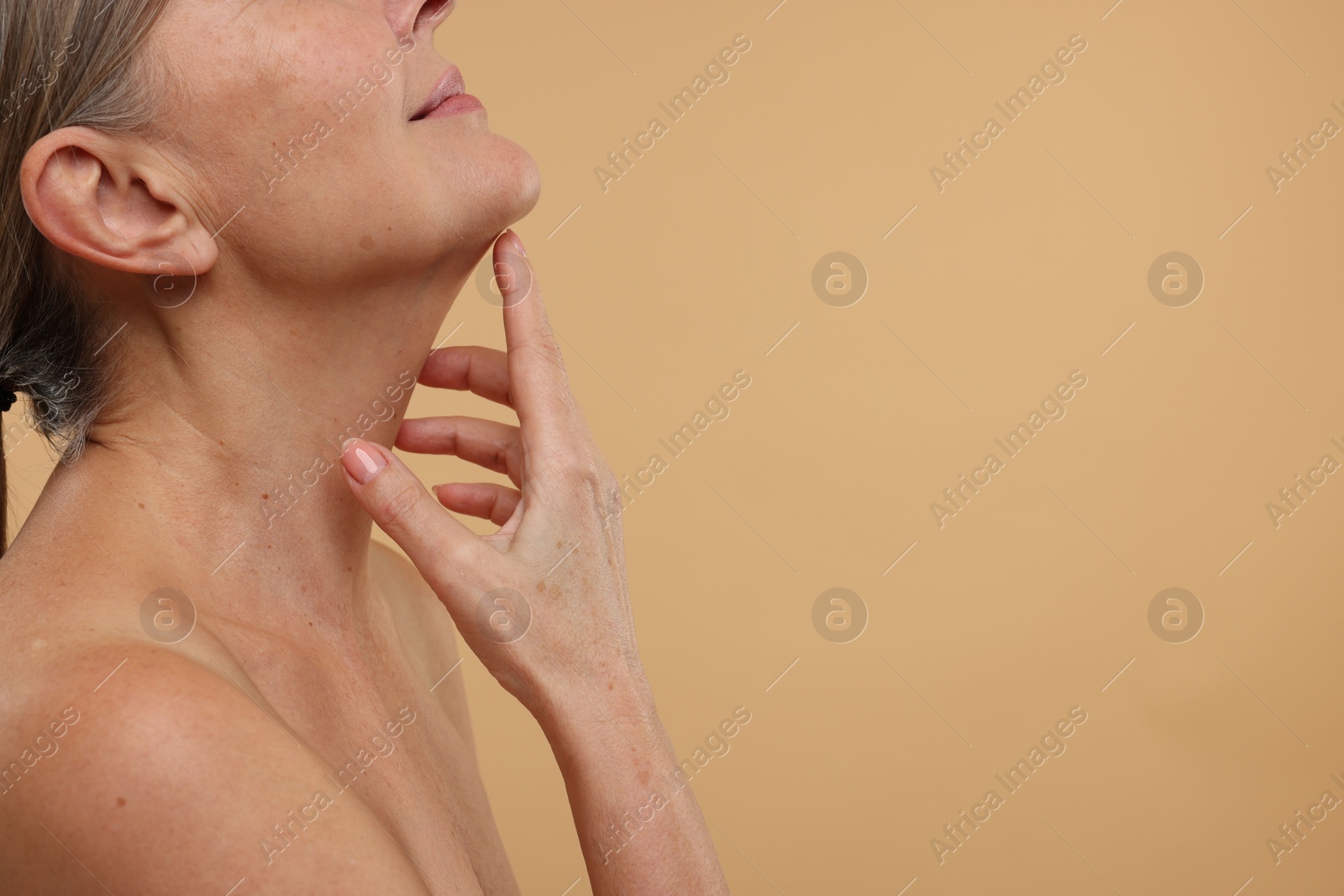 Photo of Mature woman with healthy skin on beige background, closeup. Space for text