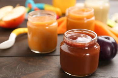 Jars with healthy baby food on table