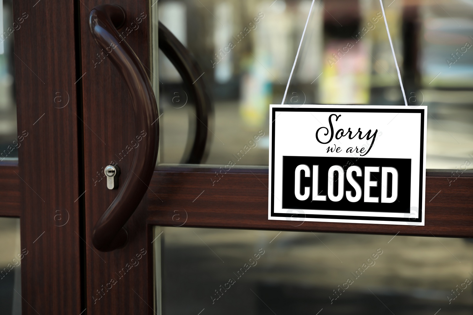 Image of Sorry we are closed sign hanging on glass door