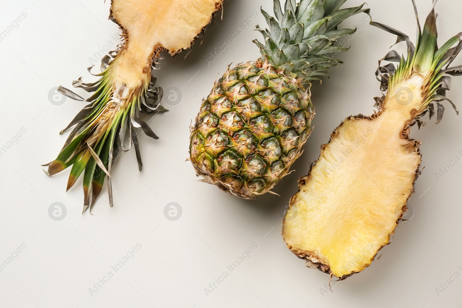 Photo of Fresh pineapples on light background, flat lay