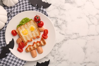 Photo of Cute monster sandwich with cherry tomatoes, fried eggs and sausages on white marble table, flat lay and space for text. Halloween snack