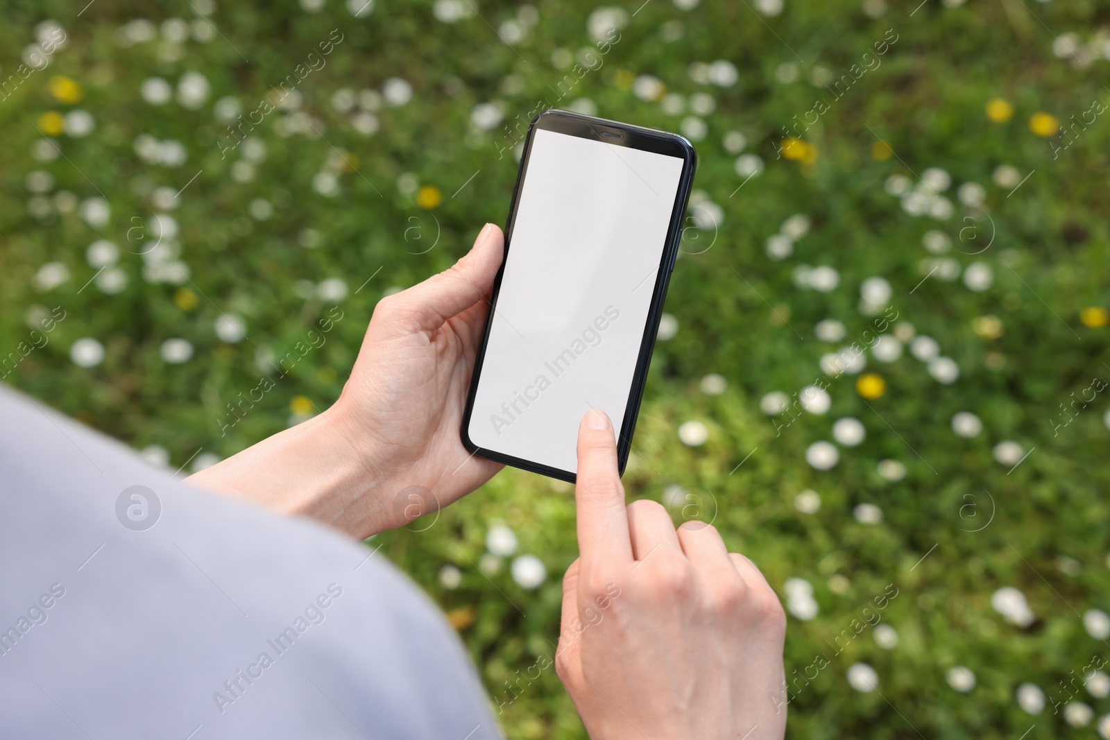 Photo of Woman using mobile phone outdoors, closeup view