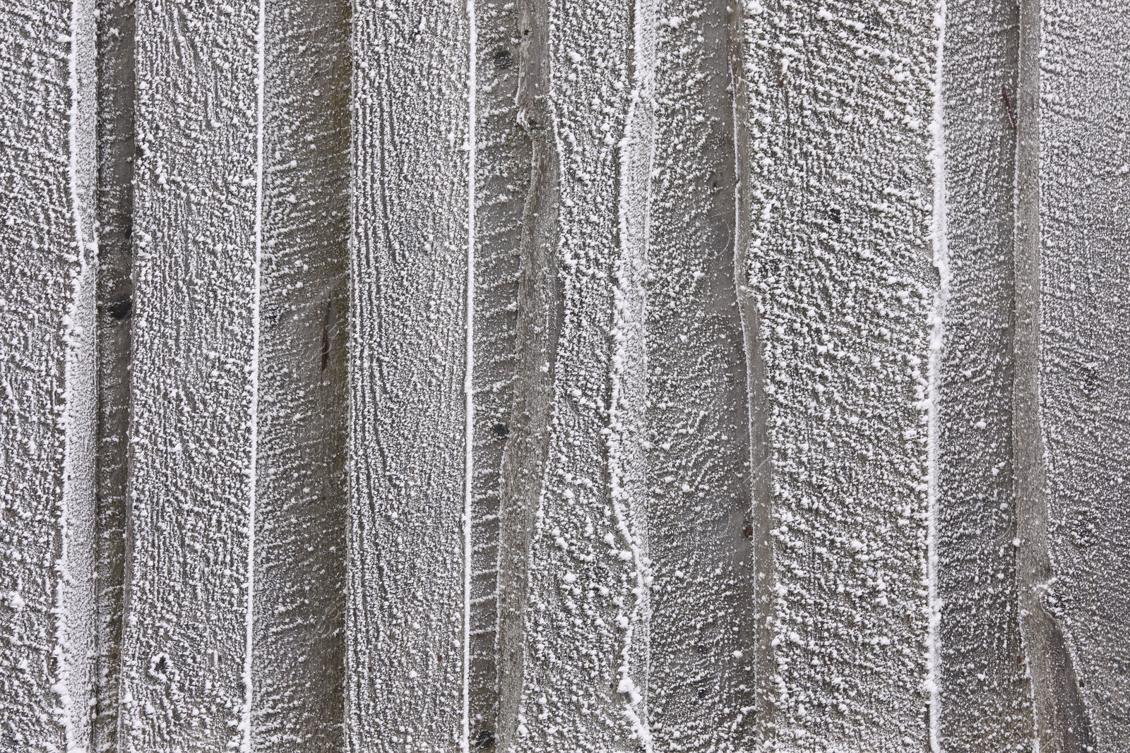 Photo of Wooden wall covered with hoarfrost on snowy day, closeup