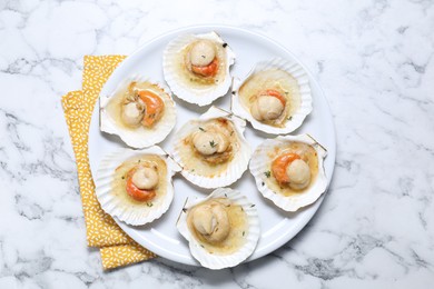 Photo of Fried scallops in shells on white marble table, top view