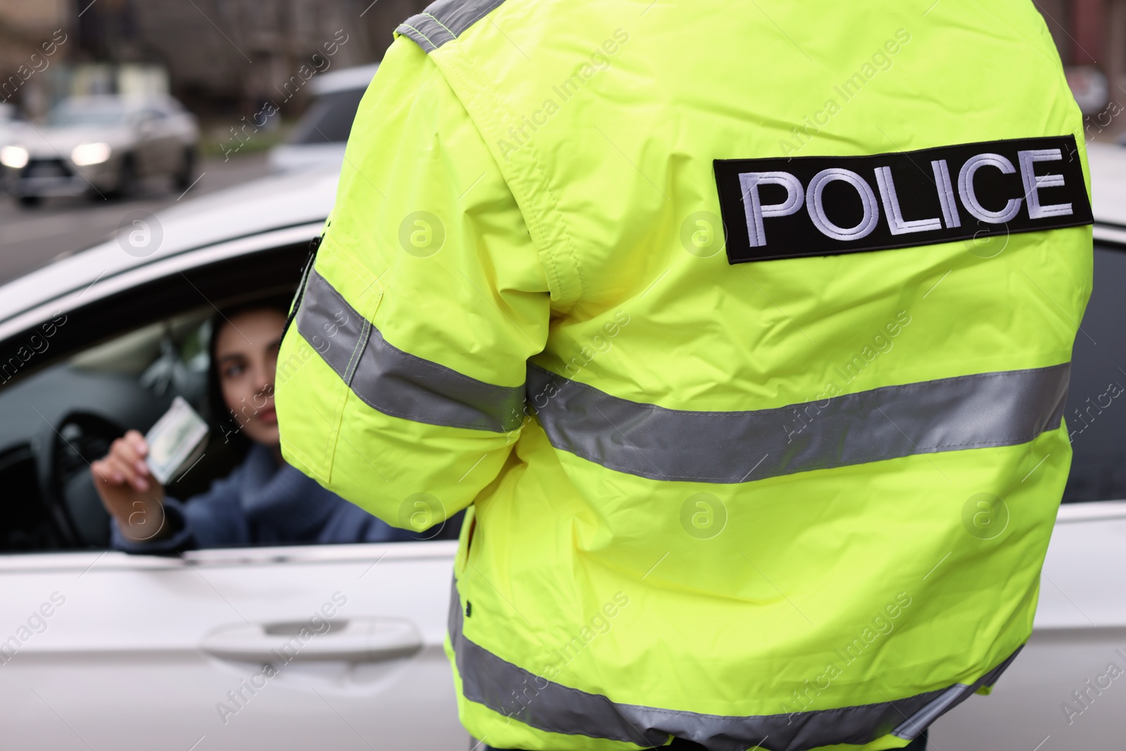 Photo of Woman giving bribe to police officer out of car window, closeup