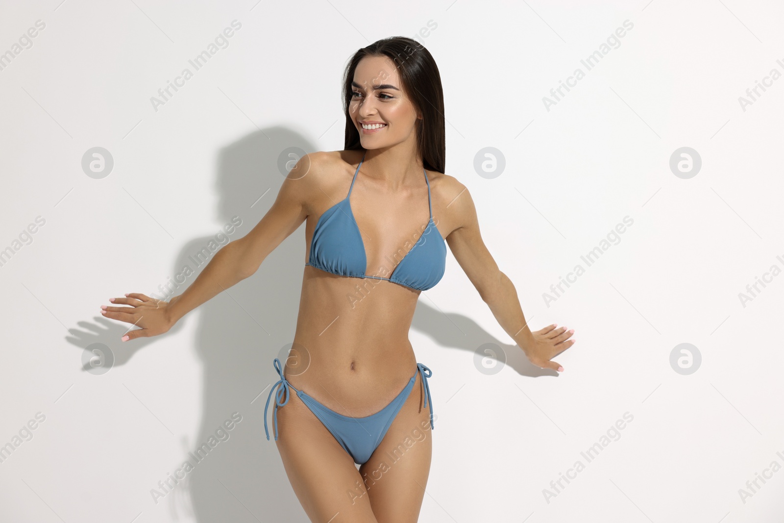 Photo of Young woman in stylish bikini on white background