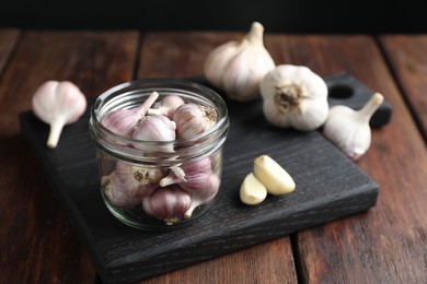 Many fresh garlic bulbs on wooden table