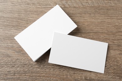 Blank business cards on wooden background, flat lay. Mockup for design