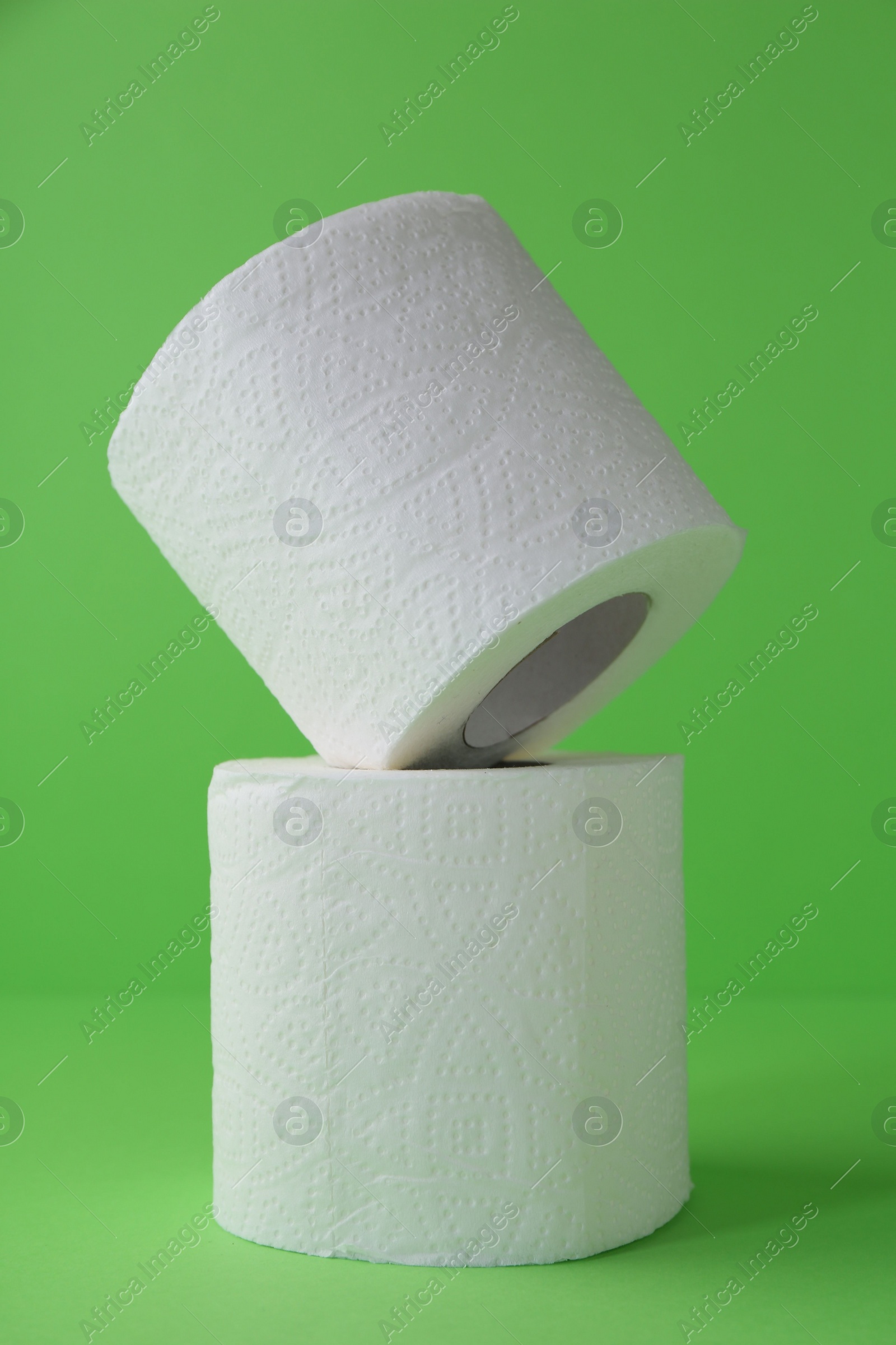 Photo of Soft toilet paper rolls on green background, closeup