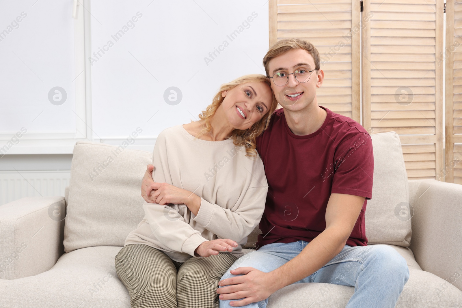 Photo of Mother and son spending time together on sofa at home. Family bonding