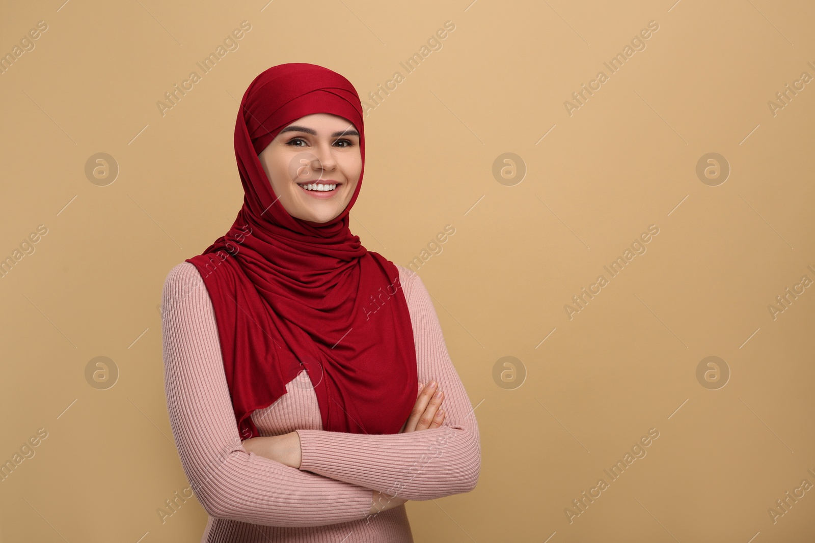 Photo of Portrait of Muslim woman in hijab on beige background, space for text