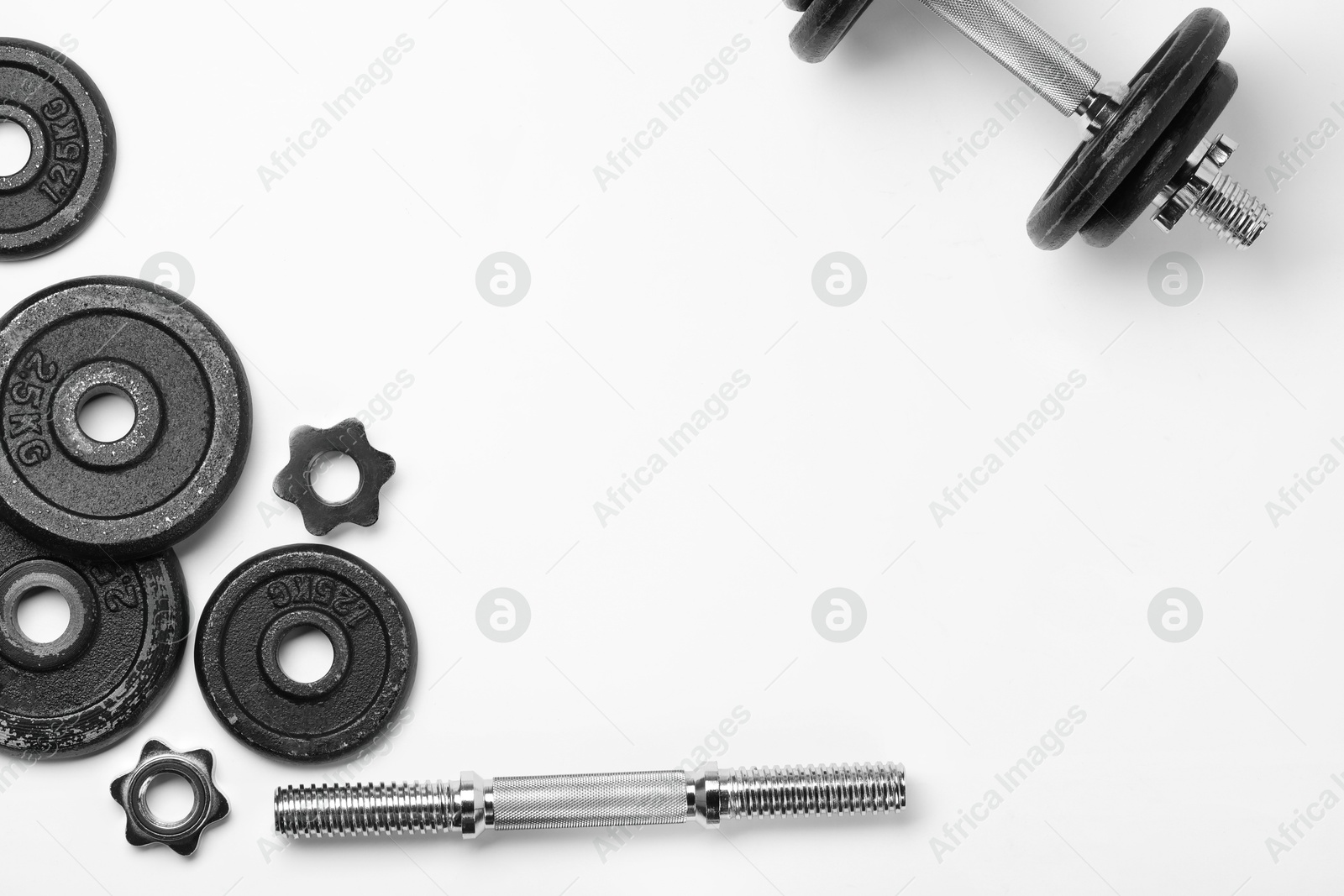 Photo of Metal dumbbell and parts on white background, top view. Sports equipment