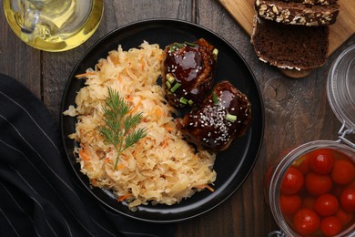 Photo of Plate with sauerkraut, chicken and products on wooden table, flat lay