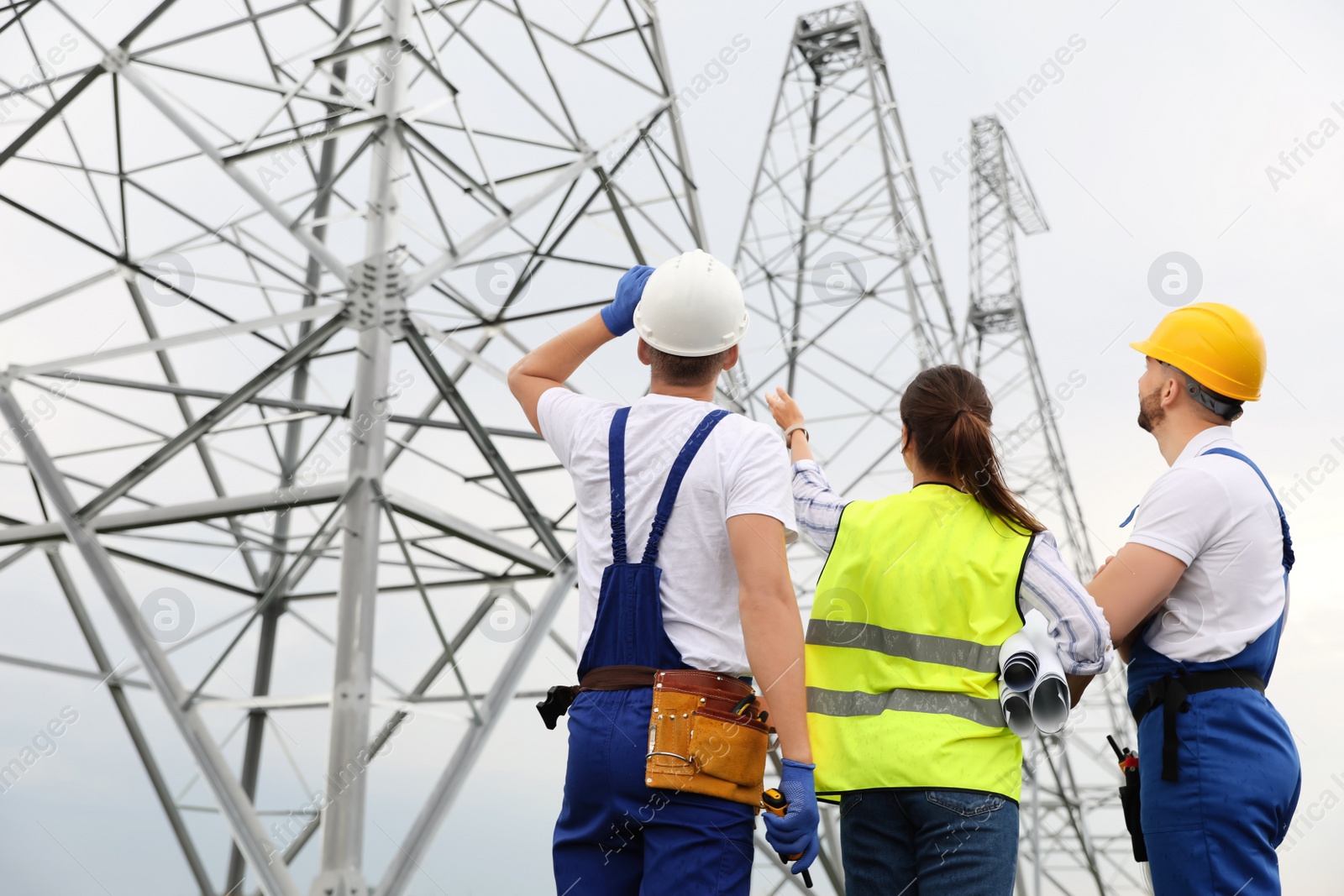 Photo of Professional engineers working on installation of electrical substation outdoors