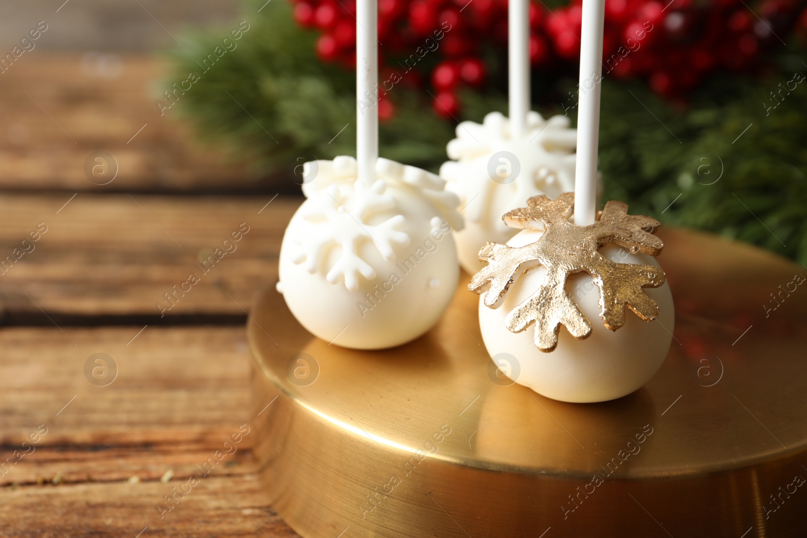 Photo of Delicious Christmas ball cake pops on wooden table, closeup