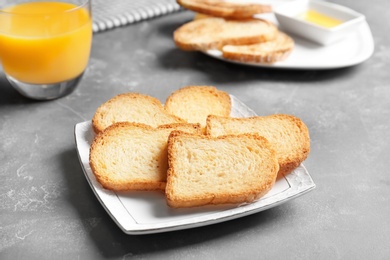 Photo of Plate with toasted bread on table