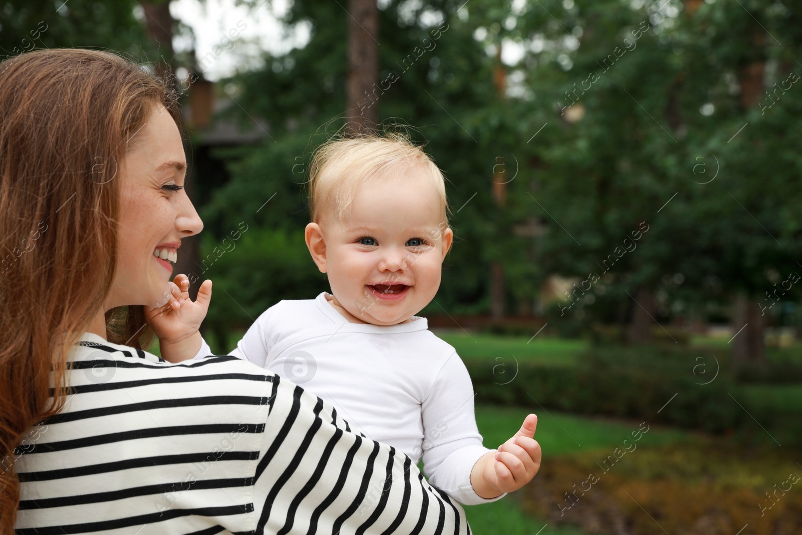 Photo of Mother with her cute baby spending time together outdoors. Space for text