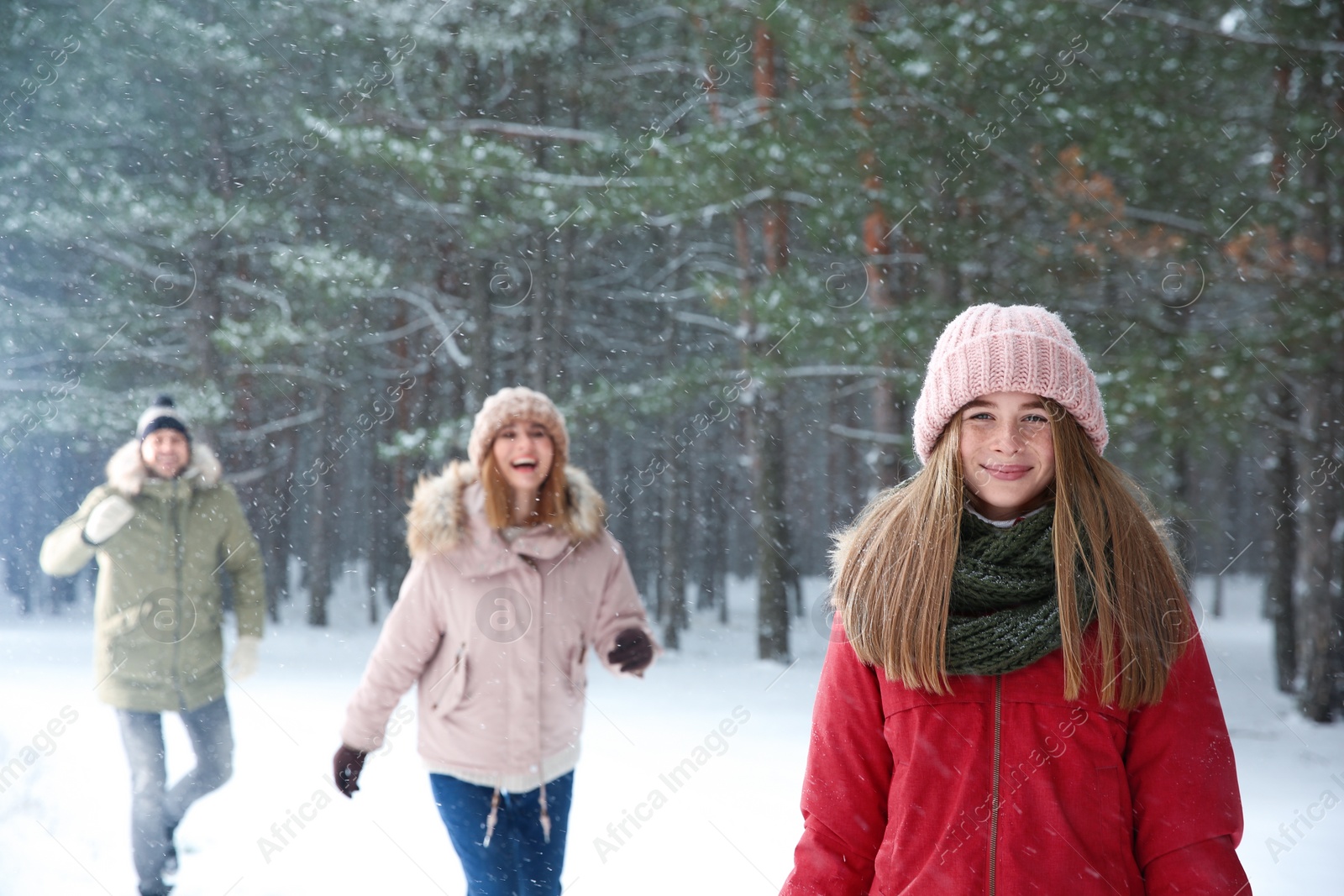 Photo of Teenage girl with family in snowy winter forest