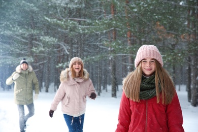 Photo of Teenage girl with family in snowy winter forest