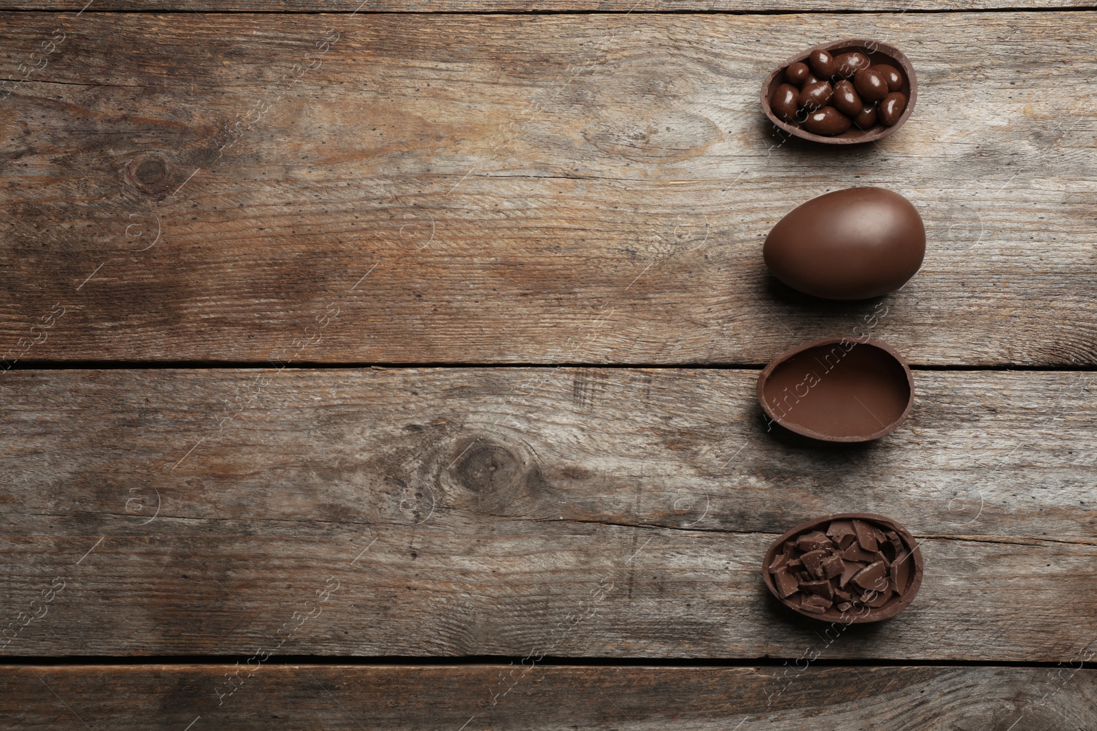 Photo of Flat lay composition with chocolate Easter eggs on wooden background, space for text