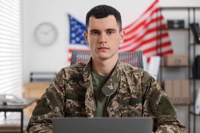 Photo of Military service. Young soldier working in office