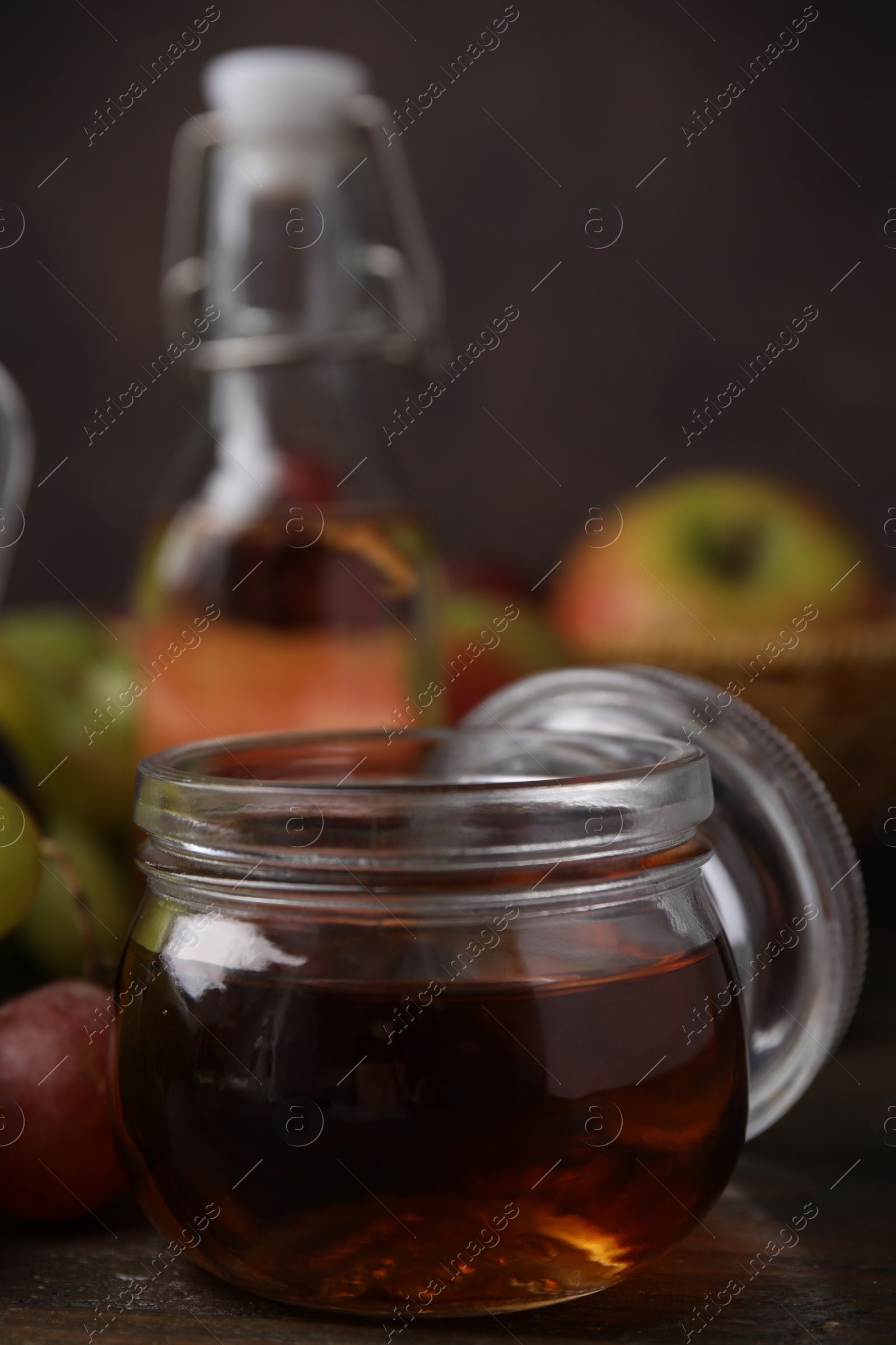 Photo of Vinegar in glass jar on wooden table