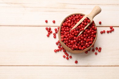 Photo of Aromatic spice. Red pepper in bowl and scoop on white wooden table, top view. Space for text