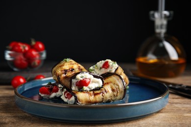 Delicious baked eggplant rolls served on wooden table