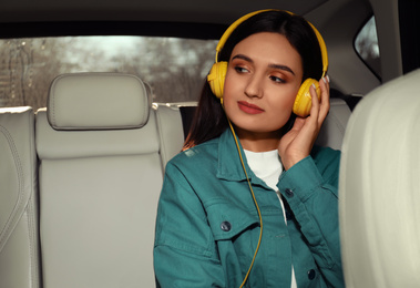 Young woman listening to audiobook in car