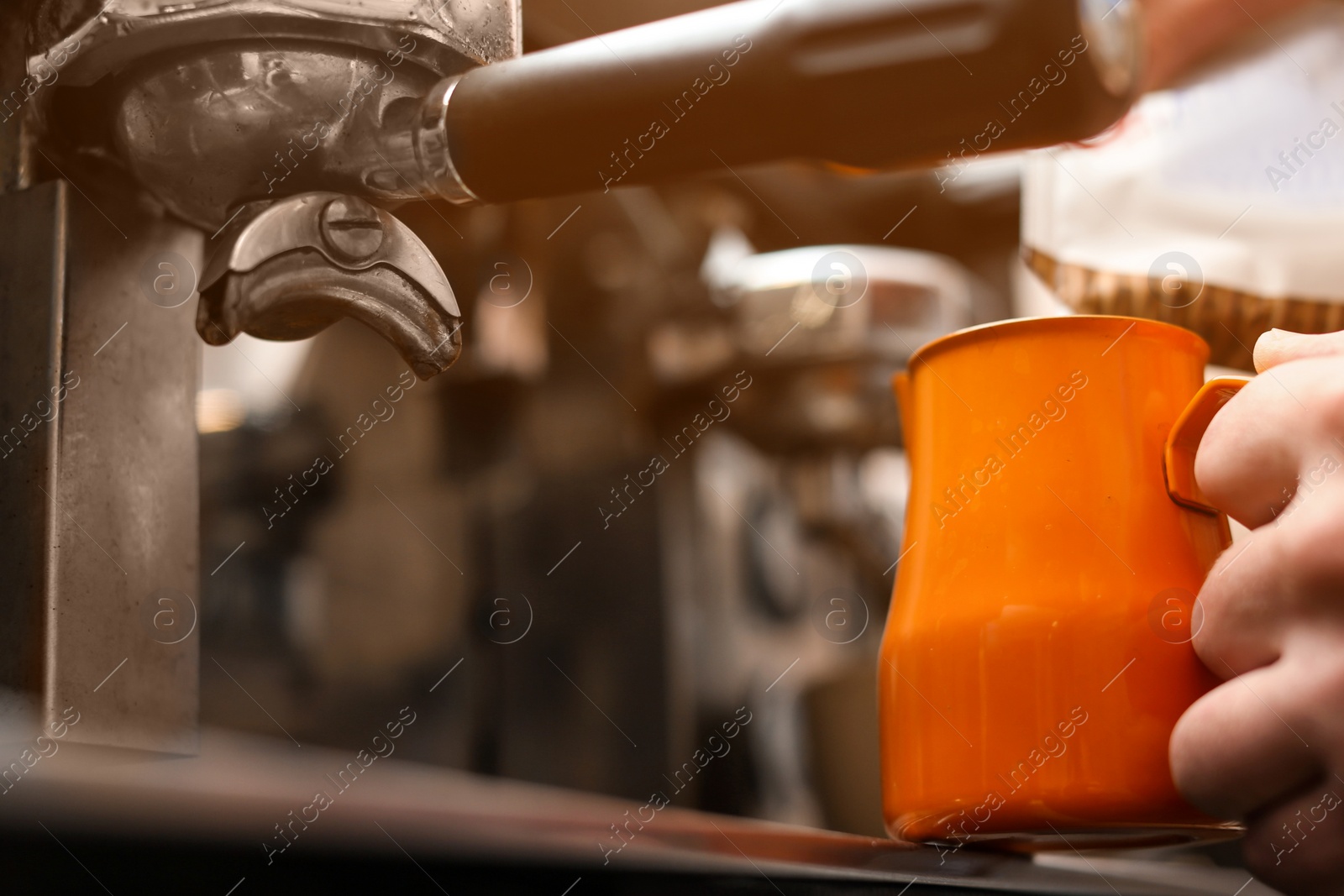 Photo of Male barista making espresso using professional coffee machine, closeup