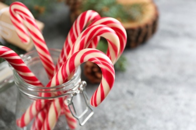 Photo of Christmas candy canes in glass jar, closeup. Space for text