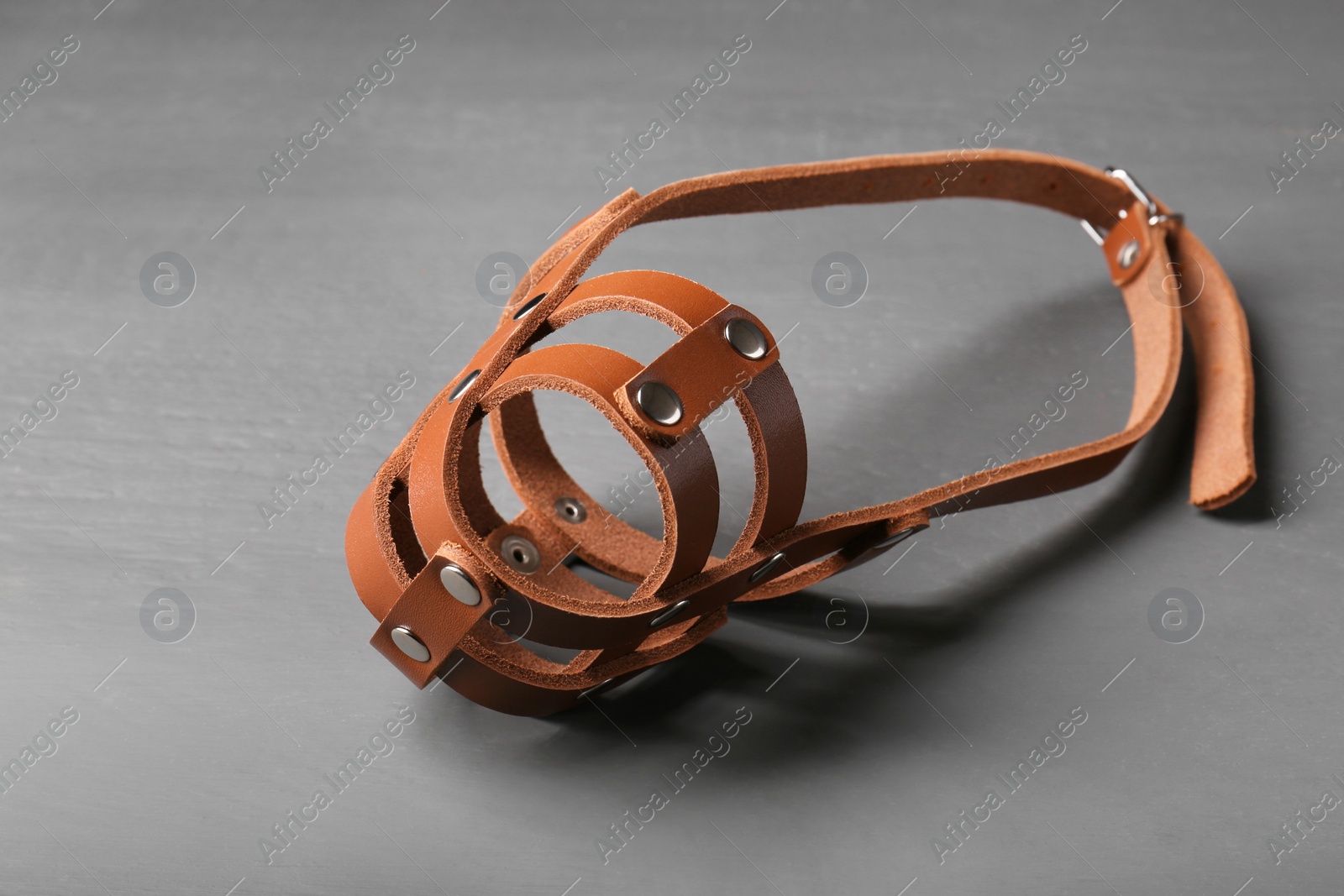 Photo of Brown leather dog muzzle on gray wooden table