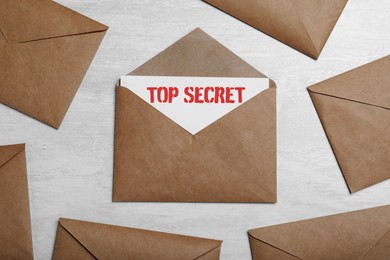 Image of Top Secret stamp. Paper envelopes on light grey table, flat lay