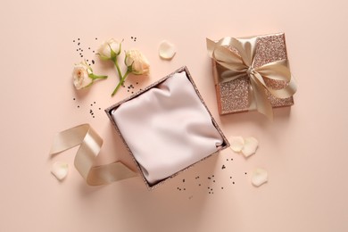 Photo of Open gift box, confetti and roses on pink background, flat lay.