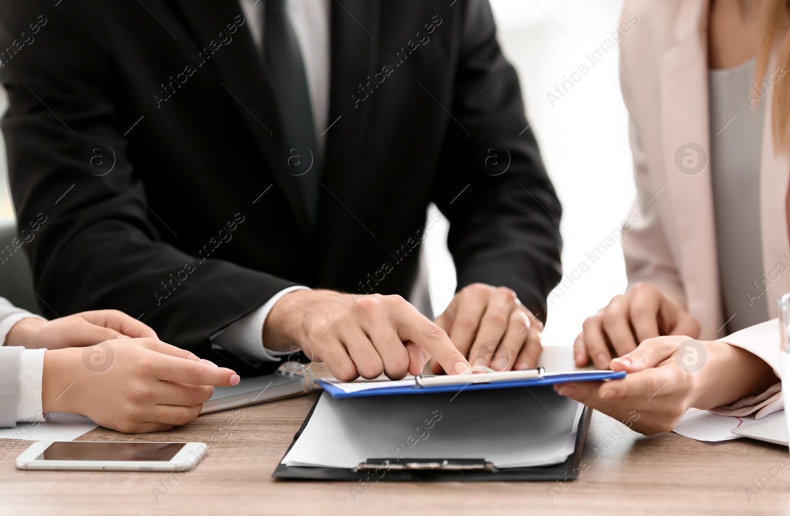 Photo of Young consultant working with clients in office