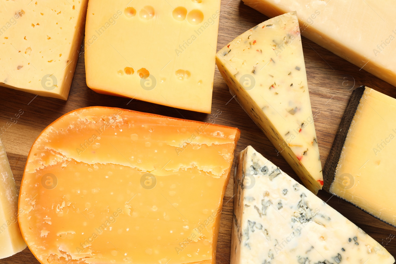 Photo of Different kinds of cheese on wooden background, flat lay