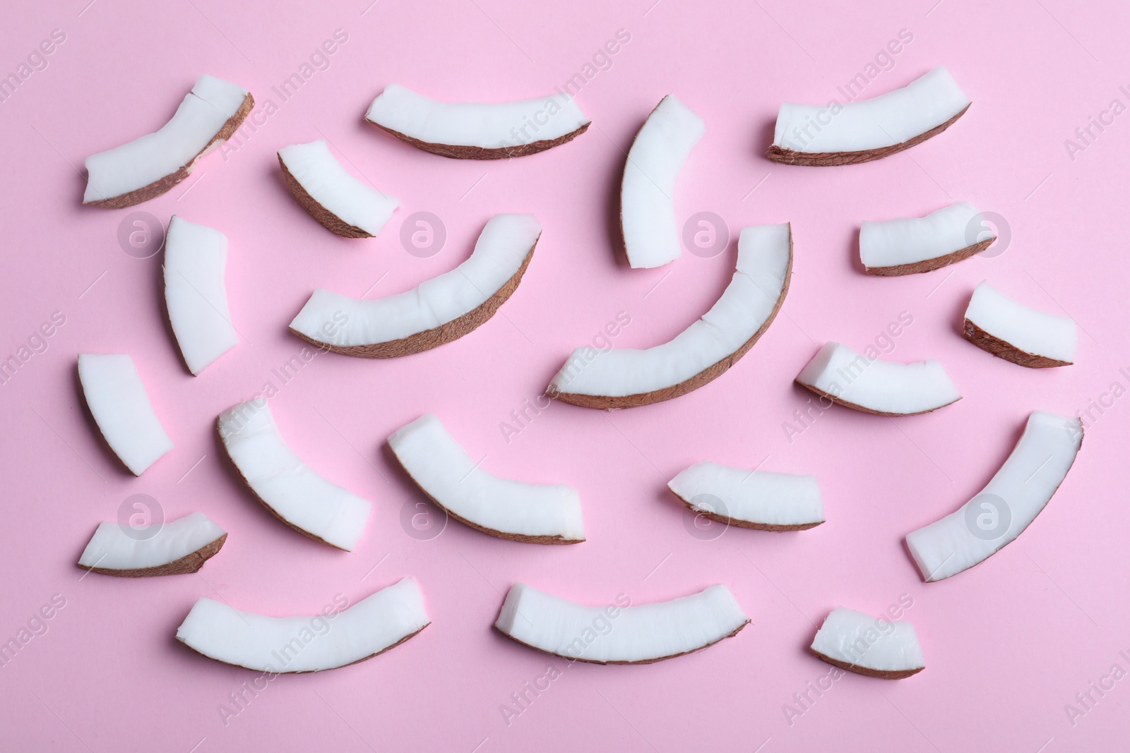 Photo of Fresh coconut pieces on pink background, flat lay
