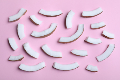 Fresh coconut pieces on pink background, flat lay