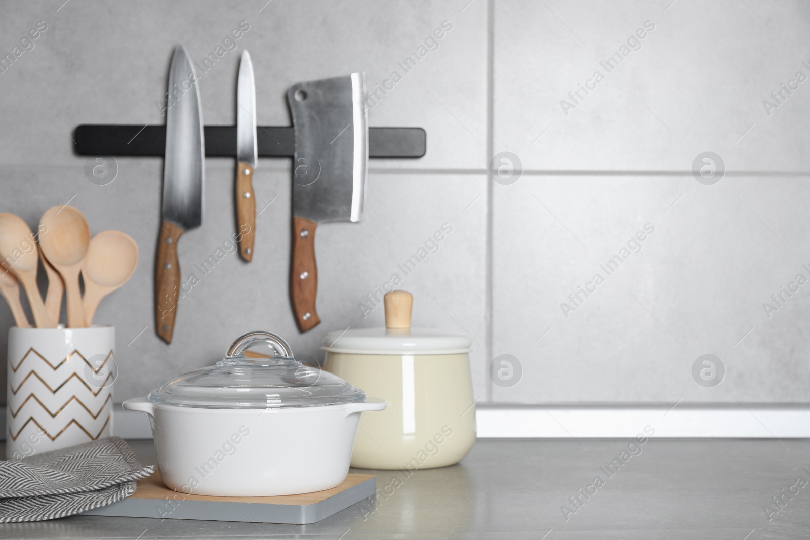 Photo of Cooking utensils and other kitchenware on grey countertop. Space for text