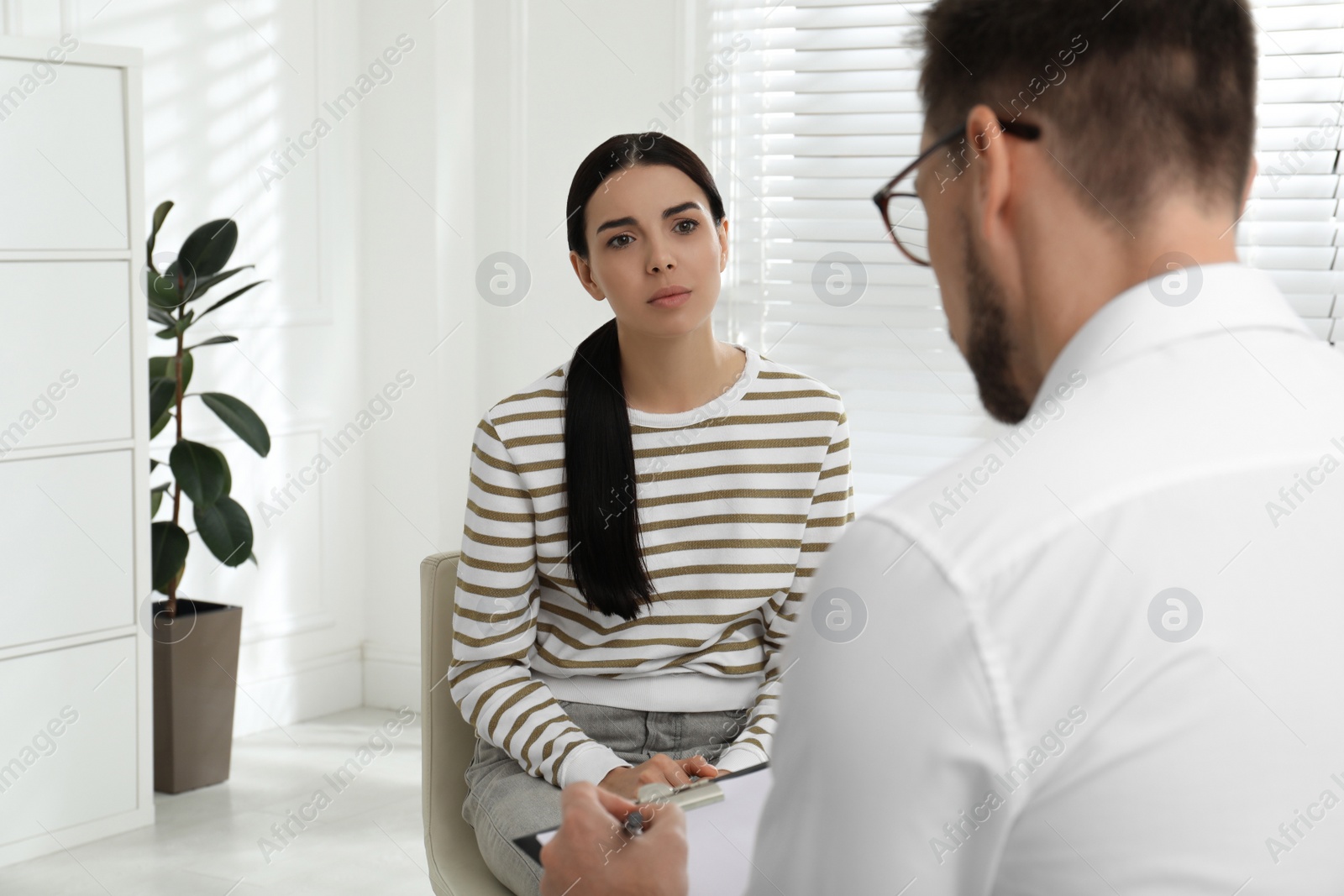 Photo of Psychotherapist working with drug addicted young woman indoors