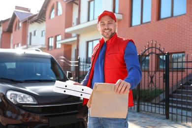 Male courier delivering food in city on sunny day