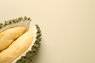 Photo of Pieces of fresh ripe durian on beige background, flat lay. Space for text
