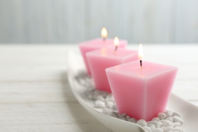 Photo of Composition with three burning candles on white table. Space for text