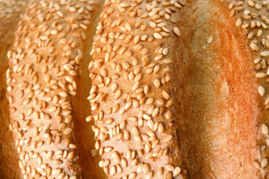 Photo of Tasty bread with sesame seeds as background, closeup