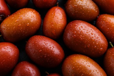 Heap of ripe red dates with water drops as background, closeup
