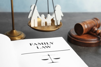 Photo of Family figure, scales of justice, gavel and book with words FAMILY LAW on table, closeup