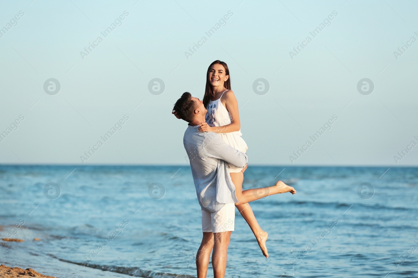 Photo of Happy young couple having fun at beach on sunny day