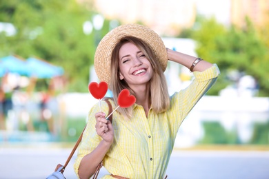 Beautiful smiling woman with candies on city street